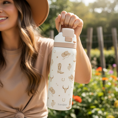 Woman holding a white water bottle with mushroom design outdoors