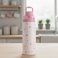 Pink water bottle with heart and grid pattern on a kitchen counter
