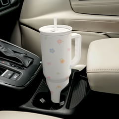 White mug with floral patterns in a car cup holder