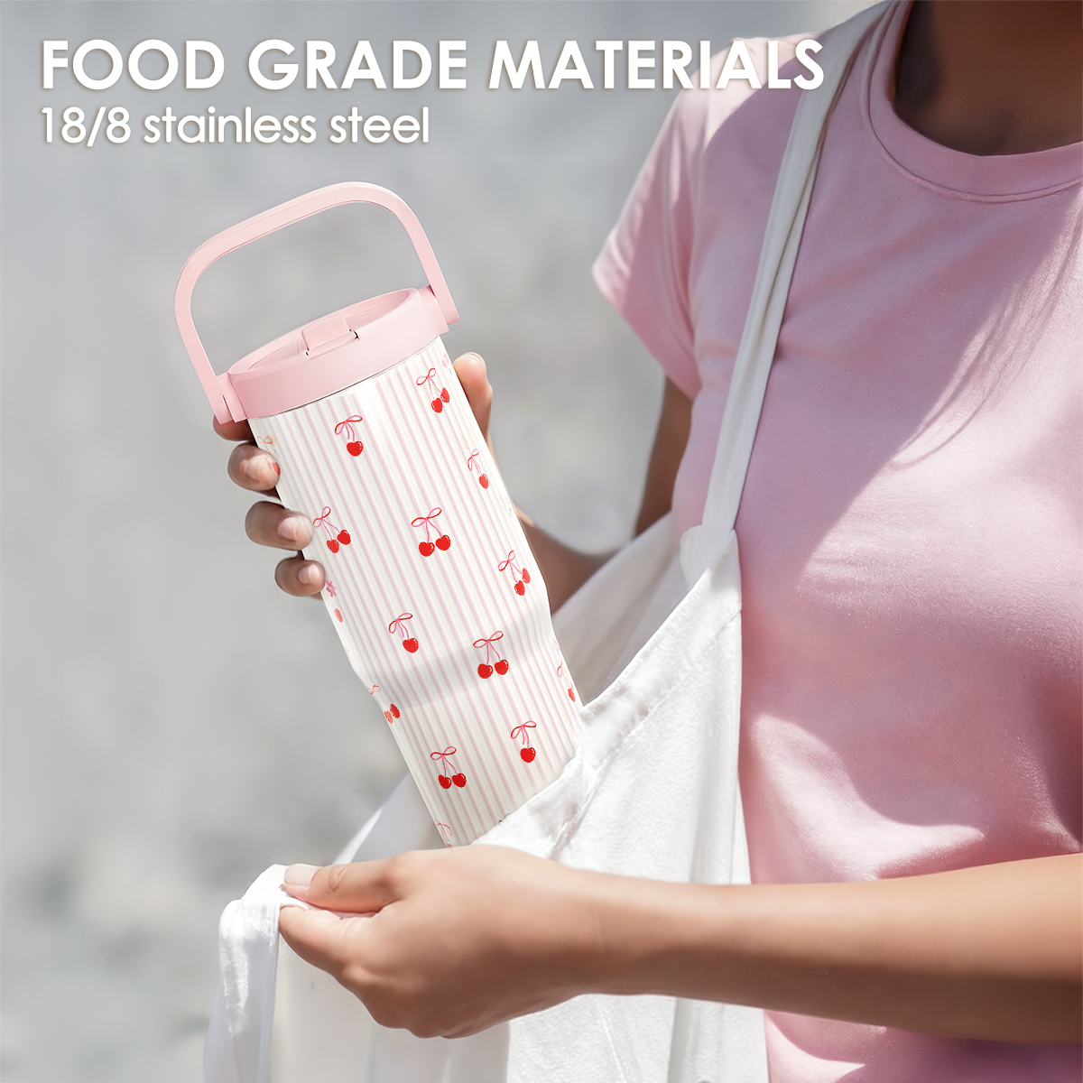 Person holding a pink and white thermos with cherry design, against a neutral background.