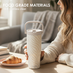 Person holding a white insulated tumbler with 'Food Grade Materials' text above.