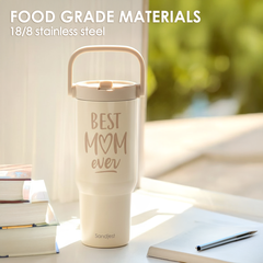 Cream-colored tumbler with 'Best Mom ever' text on a blurred outdoor background